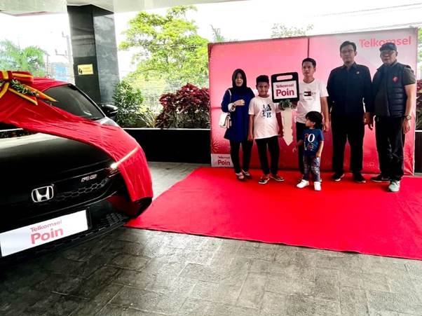 Manager Branch Telkomsel Banjarmasin M. Norhansyah bersama Manager Network Service Telkomsel Banjarmasin Heri Suryanto menyerahkan 1 unit mobil Honda City Hatchback di kantor pelayanan Grapari Telkomsel Banjarmasin Jl. A. Yani Km 5.2 pada Rabu (11/01) kepada Devi Rizki Hernanda, pelanggan Telkomsel dari Amuntai Tengah Kabupaten Hulu Sungai Selatan Kalimantan Selatan berhasil meraih hadiah dalam program Telkomsel POIN Undi Undi Hepi tahun 2022 periode 27.