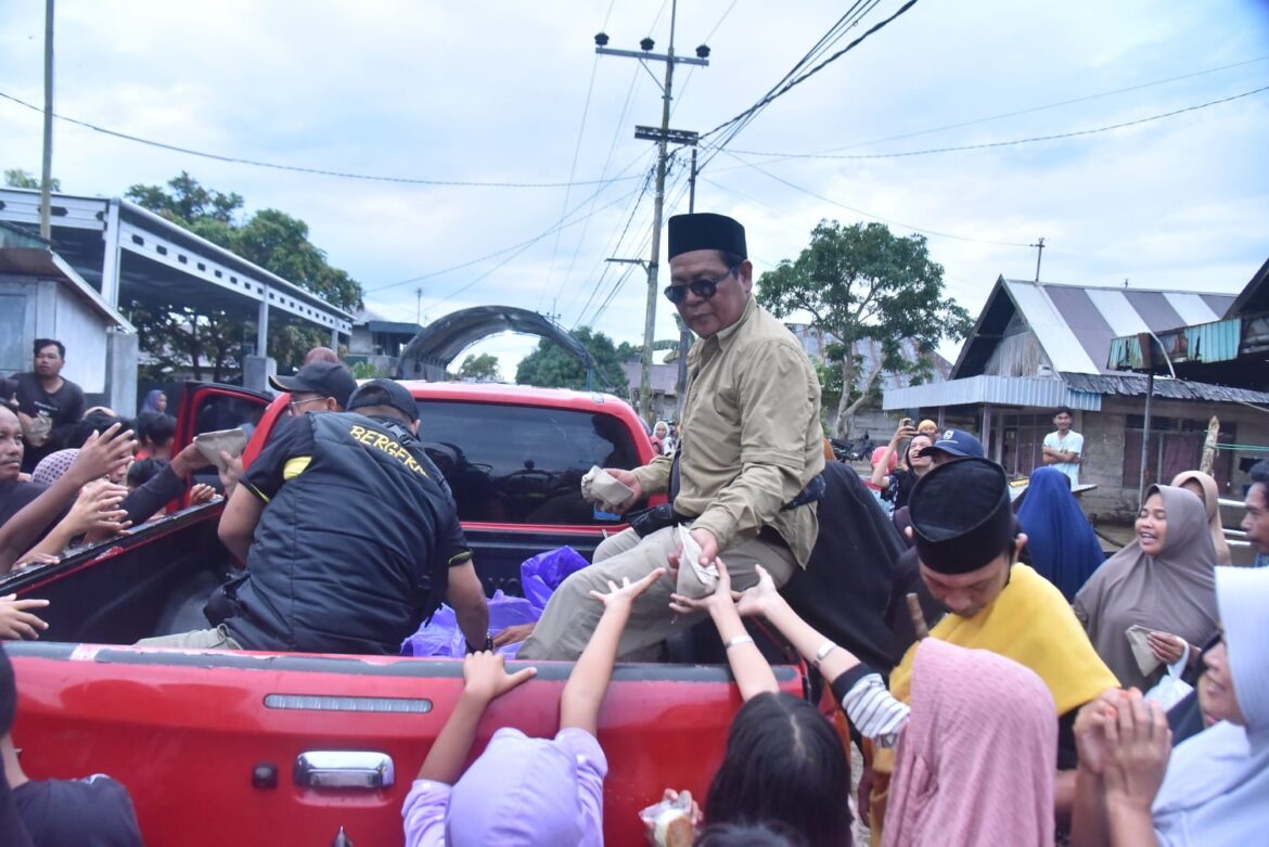 Gubernur Kalsel, Sahbirin Noor atau Paman Birin bersama kepala SKPD Pemprov Kalsel, membagikan nasi bungkus dan bantuan saat mengumjungi warga  terdampak banjir di Martapura Barat, Kabupaten Banjar, Kamis (2/3). (foto:adpim).