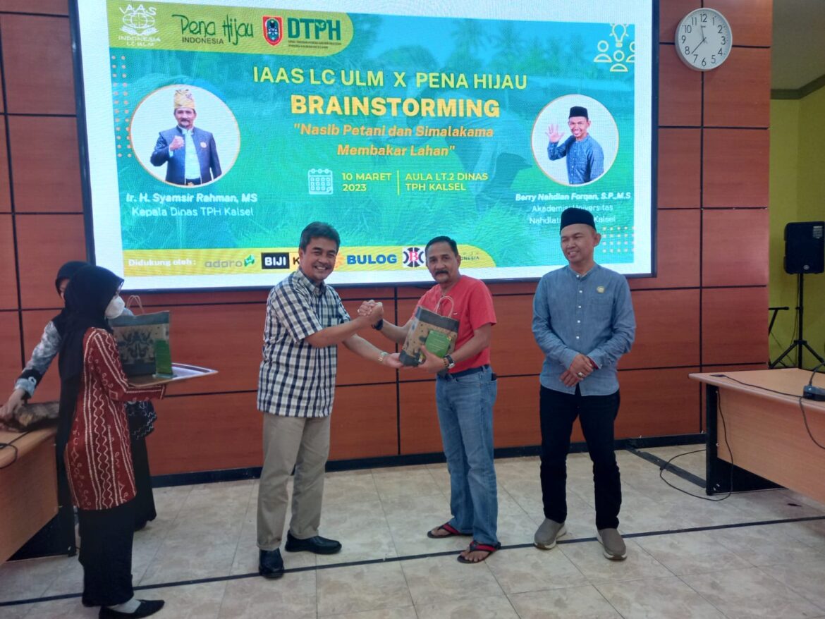 Prof Fadli H Yusran, Pembina IAAS LC Universitas Lambung Mangkurat (ULM) saat memberikan siuvenir acara diskusi kepada Kepala Dinas Tanaman Pangan dan Holtikultura (TPH) Provinsi Kalsel Syamsir Rahman, Jumat (10/3/2023).(foto : sum/brt)