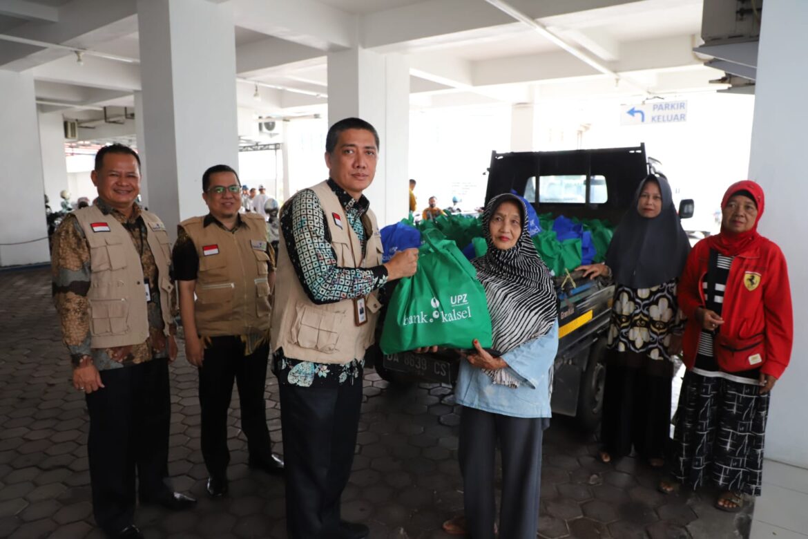 Plt. Direktur Utama Bank kalsel, Fachrudin, menyampaikan pembagian bantuan paket sembako kepada salah satu warga (foto:bank kalsel)