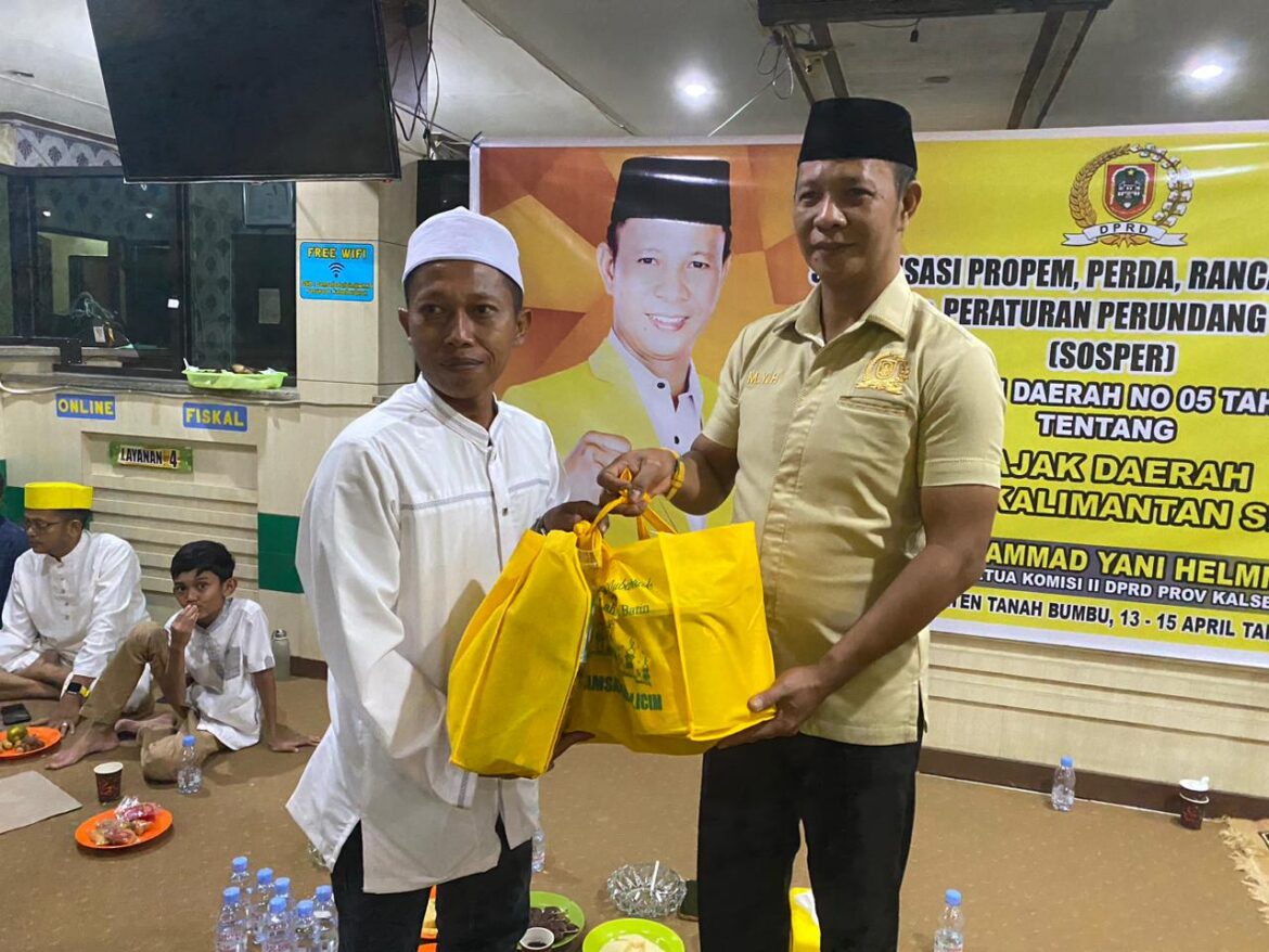 Wakil Ketua Komisi II DPRD Provinsi Kalsel Muhammad Yani Helmi saat menyerahkan bingkisan dari UPPD Samsat Batulicin kepada wajib pajak yang taat bayar pajak dan tepat waktu.(foto : ist)
