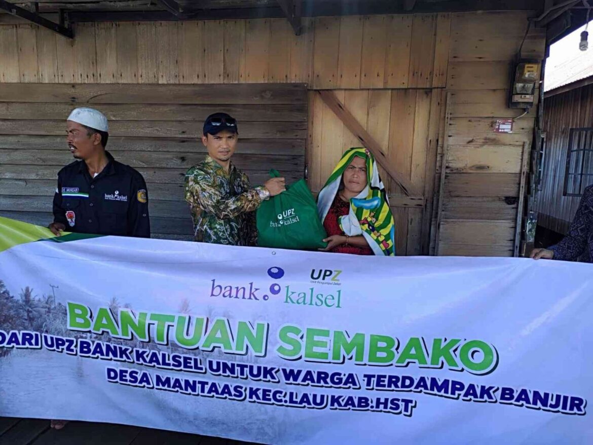 Kepala Bank Kalsel Cabang Barabai, Muhaini Achyar menyerahkan paket sembako kepada salah satu warga Desa Mantaas (foto:istimewa)