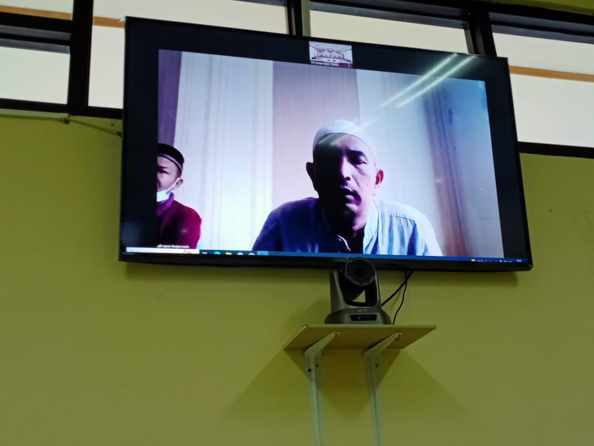 Salah satu terdakwa perkara pembebasan lahan Proyek Bendungan di Kabupaten Tapin saat mengikuti sidang secara virtual.