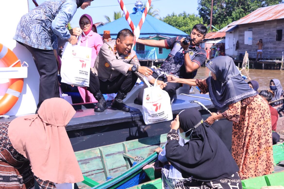 BAGI SEMBAKO -Puluhan Warga di sungai Mantuil antusias saat menerima pembagian sembako gratis dari Kapolresta Banjarmasin Kombes Pol Sabana Atmojo Martosumito beserta istri, Kamis (22/5/2023) pagi. (foto:ist