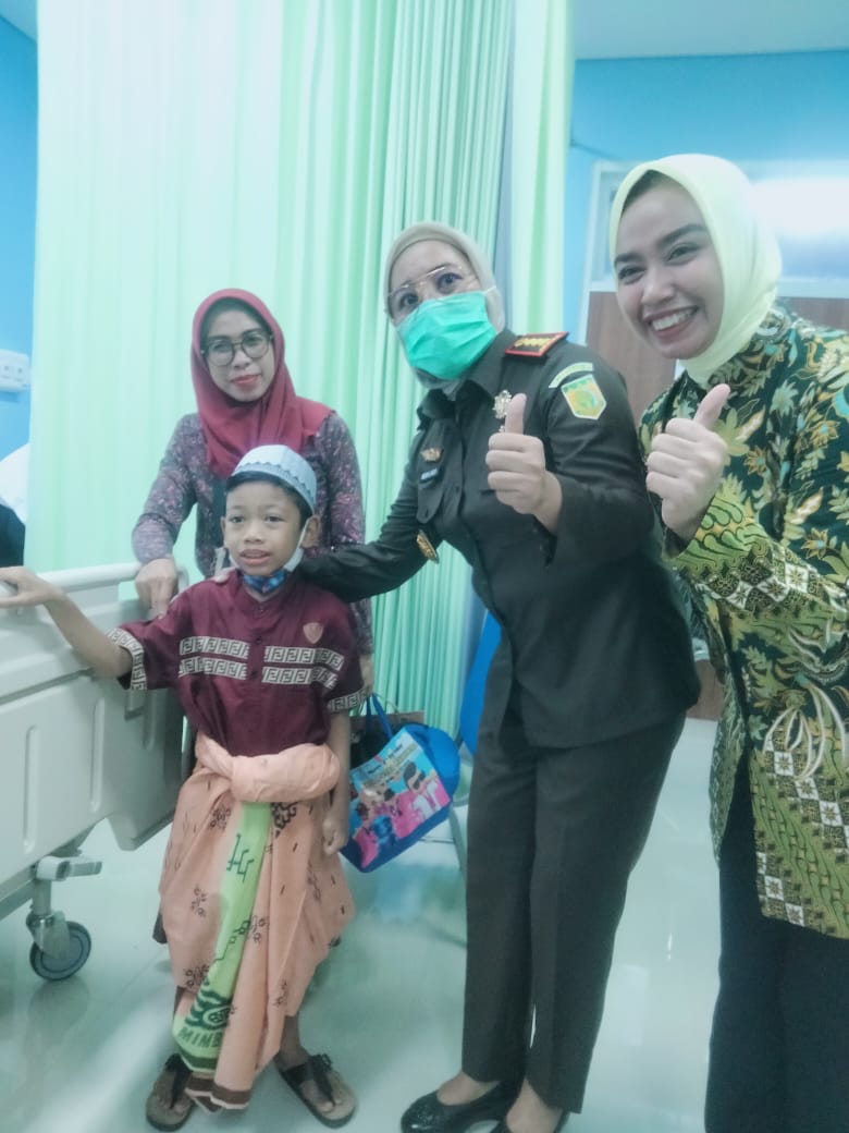Kajari Banjarmasin Indah Laila SH MH dan Ketua IAD Kejari Banjarmasin Gisa Dimas saat menyerahkan bingkisan kepada salah satu peserta sunatan.