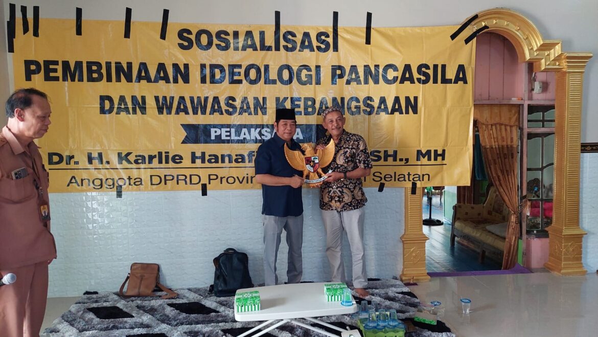 Anggota DPRD Provinsi Kalsel Dr H Karlie Hanafi Kalianda, SH MH menyerahkan Lambang Negara berupa ukiran Burung Garuda kepada Sayuti, Kepala Desa Anjir Pasar Seberang II Kecamatan Anjir Pasar Kabupaten Barito Kuala, Senin (17/7/2023).(foto : ist)