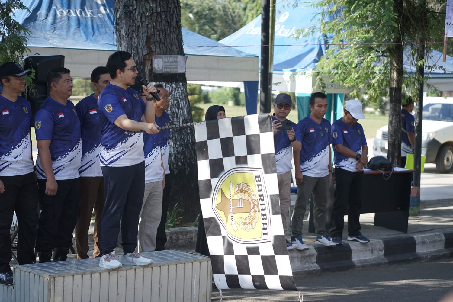 Bupati HST H Aulia Oktafiandi kibarkan bendera start dimulainya lomba gerak jalan antara pelajar semarakan Dirgahayu RI ke-78 Tahun 2023.(foto : yufanata/brt)