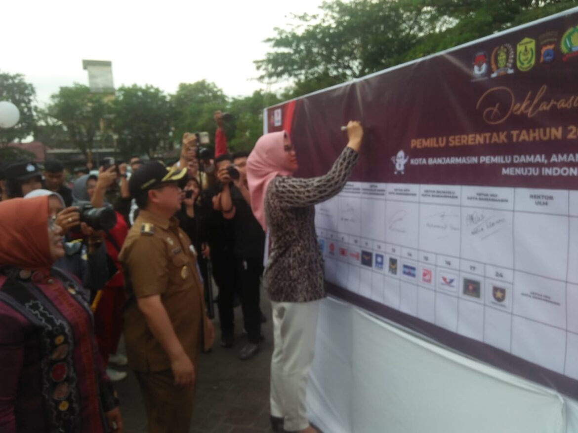 TANDA TANGAN - Ketua KPU Kalsel Andi Tenri Sompa saat menandatangani Deklarasi Pemilu Damai bersama Forkopimda Banjarmasin dipimpin langsung Walikota H Ibnu Sina. (foto:sum/brt)