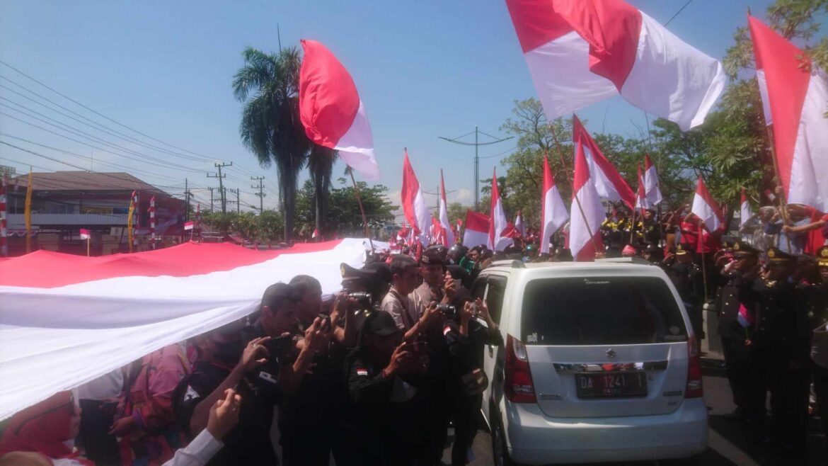 BENDERA PANJANG – Elemen beserta anggota serta sipil PNS Polresta Banjarmasin saat membentangkan bendera merah putih sepanjang 100 meter dari Mapolresta sampai ke depan Makolanal setempat, Kamis (foto/sum/brt).