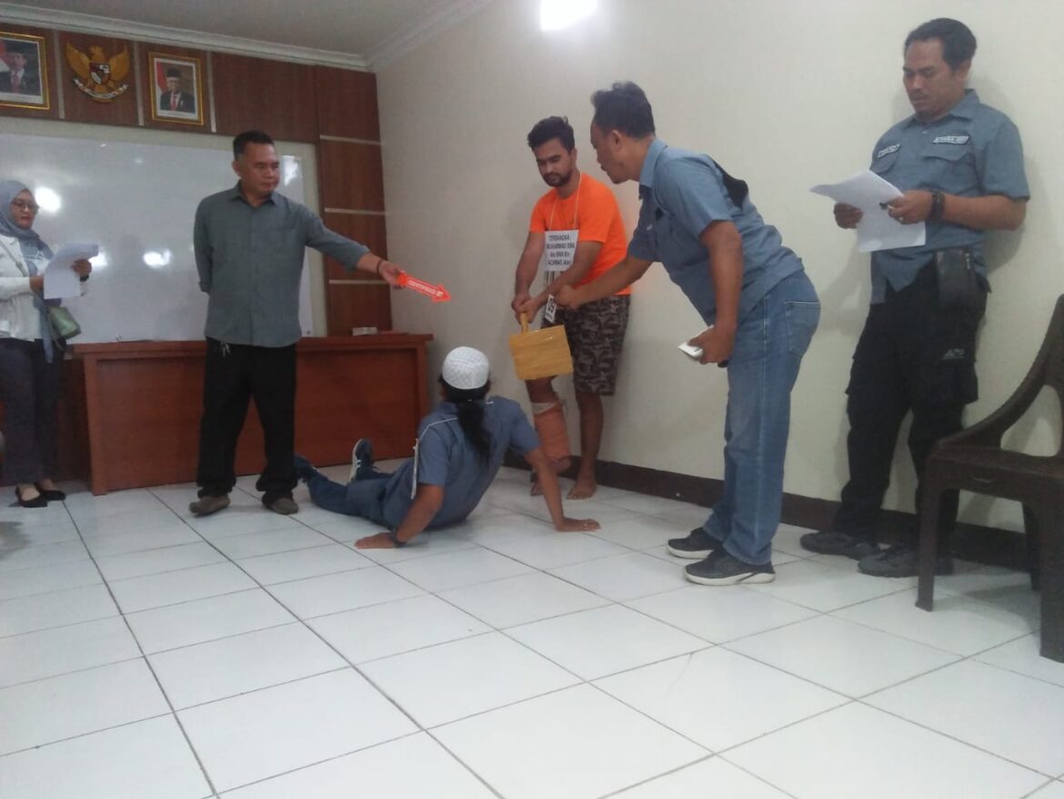 REKONSTRUKSI PEMBUNUHAN - Pelaku pembunuhan berinisial MI saat meragakan memukul kepala korbam dengan cangkul, Rabu (16/8/2023) pagi. (foto:sum/brt) 4