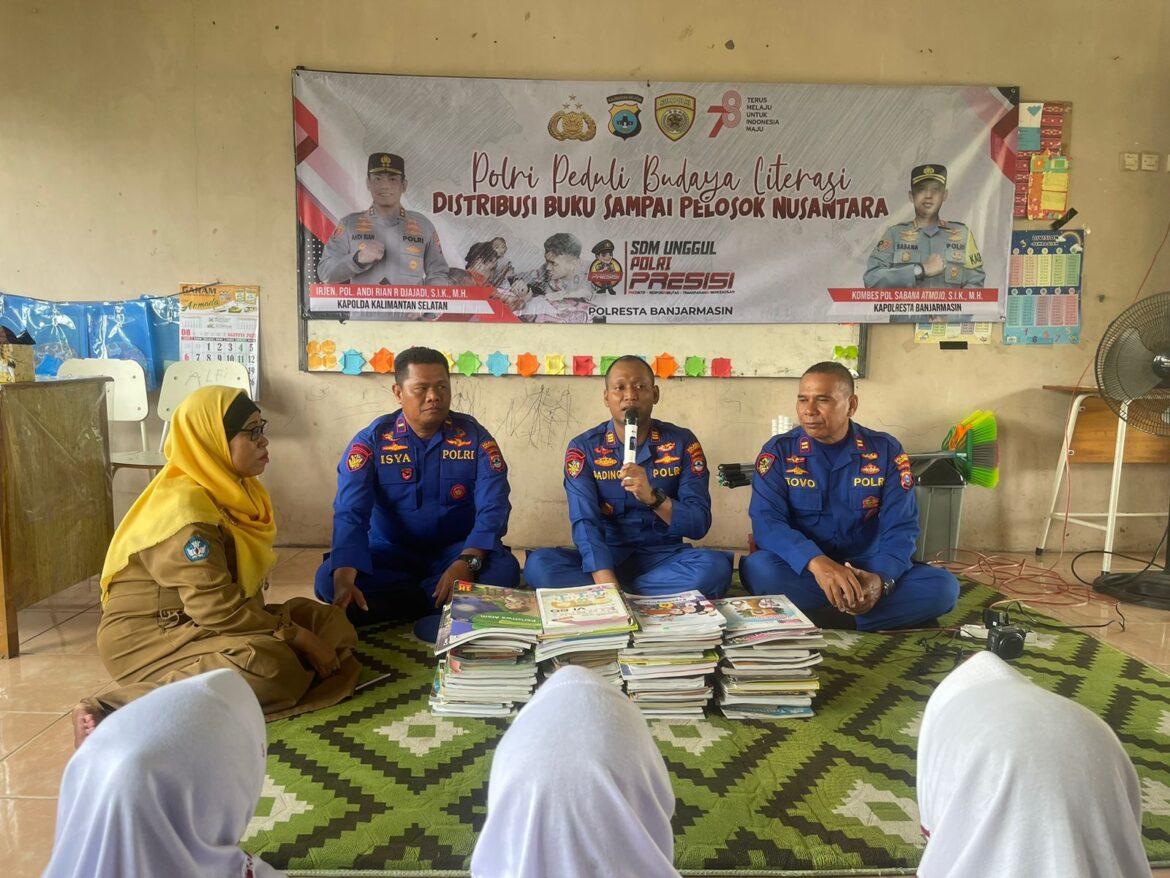 MINAT BACA - Kasat Satpolair Polresta Banjarmasin AKP Dading Kalbu Adie saat membagikan buku gratis kepada perwakilan SDN Basirih 10 Bansel, Selasa (5/9/2023). foto:ist)
