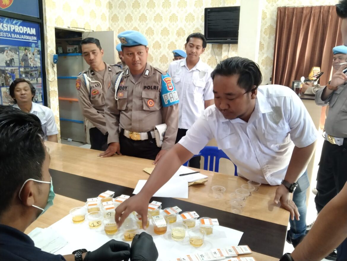 TES URIN -salah satu anggota intel Polresta Banjarmasin saat menyerahkan urinnya guna diperiksa apakah mengandung zat narkoba atau tidak, Rabu (27/9/2023). (foto:ist)
