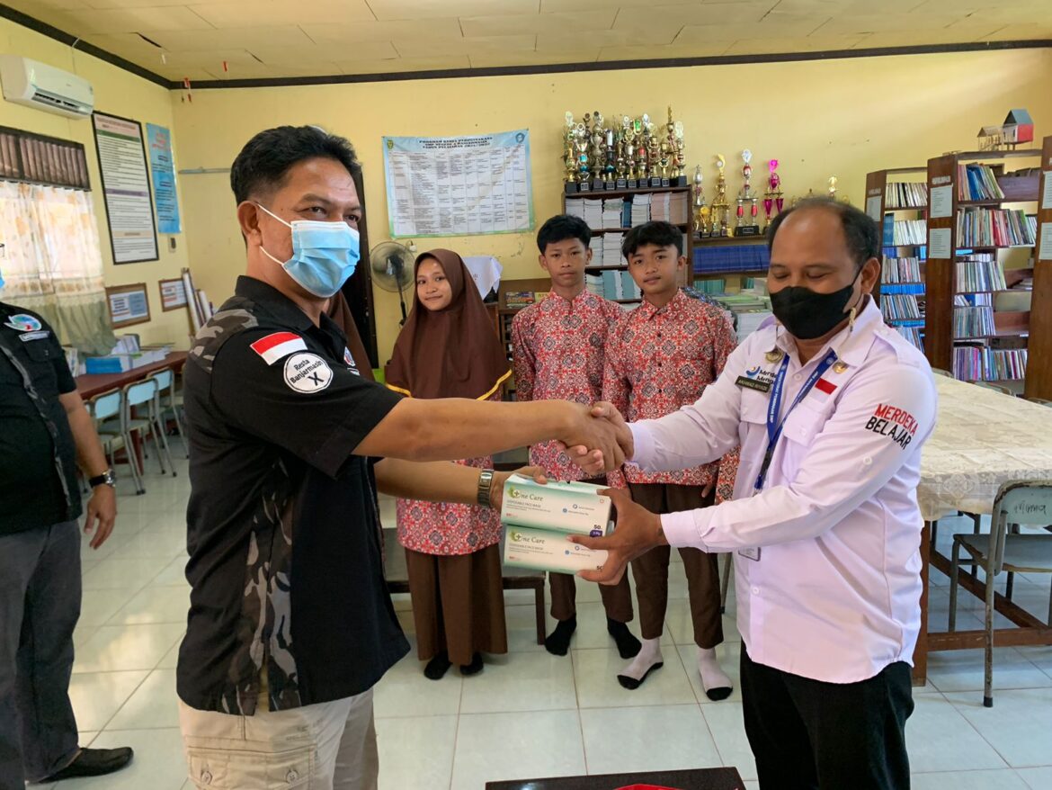 SERAHKAN MASKER - Perwakilan Sat Narkoba Polresta Banjarmasin saat meyerahkan masker kepada Kepala Sekolah SMPN 4 Akhmad Riyadi di Jalan Teluk Tiram Darat, Rabu (11/10/2023) pagi. (foto:ist)