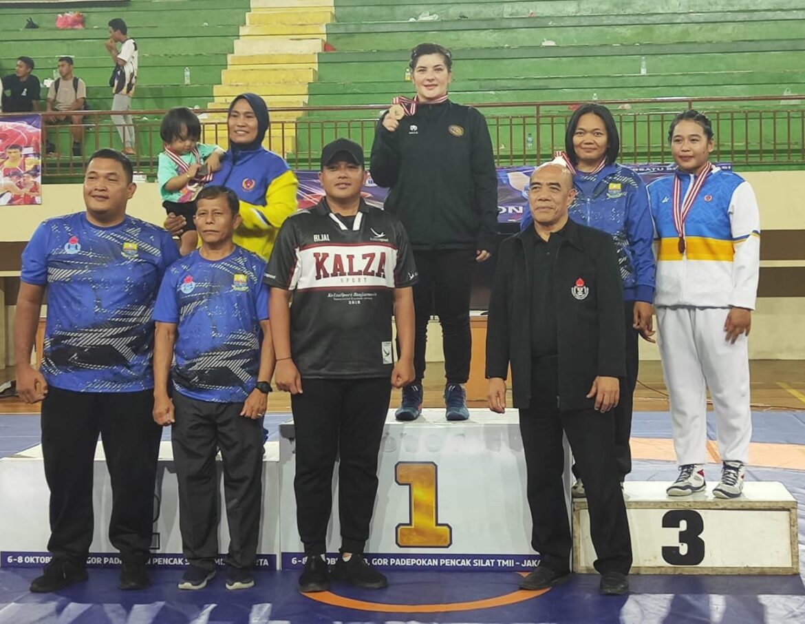 Atlet gulat Kalsel, Nastrusnicu Roxana Andrea, mendapat pengalungan medali emas Pra PON 2023 yang didampingi Sekum PGSI Kalsel, Rijal Hamid, Rabu (8/11/2023) malam di di GOR Ciracas, Jakarta Timur. (foto: ist/brt)