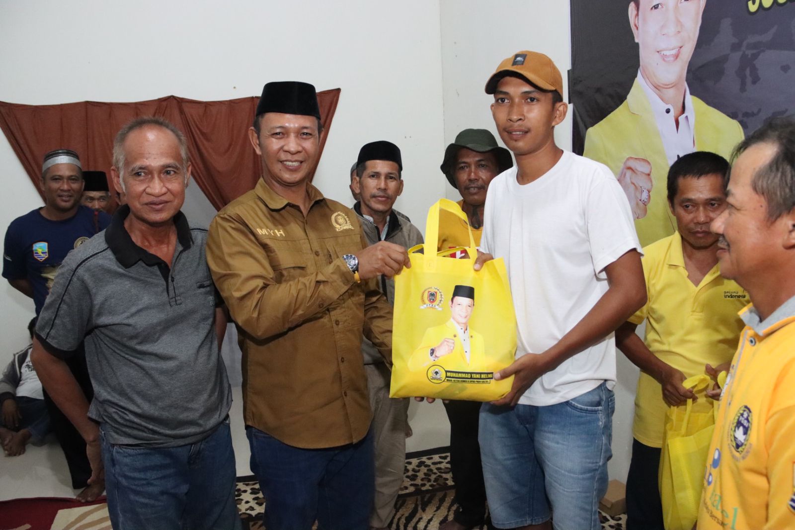 Wakil Ketua Komisi II DPRD Provinsi Kalsel Muhammad Yani Helmi usai menyampaikan materi sosialisasi dilanjutkan penyerahan bingkisan secara simbolis kepada warga yang berhadir.(foto : ist)