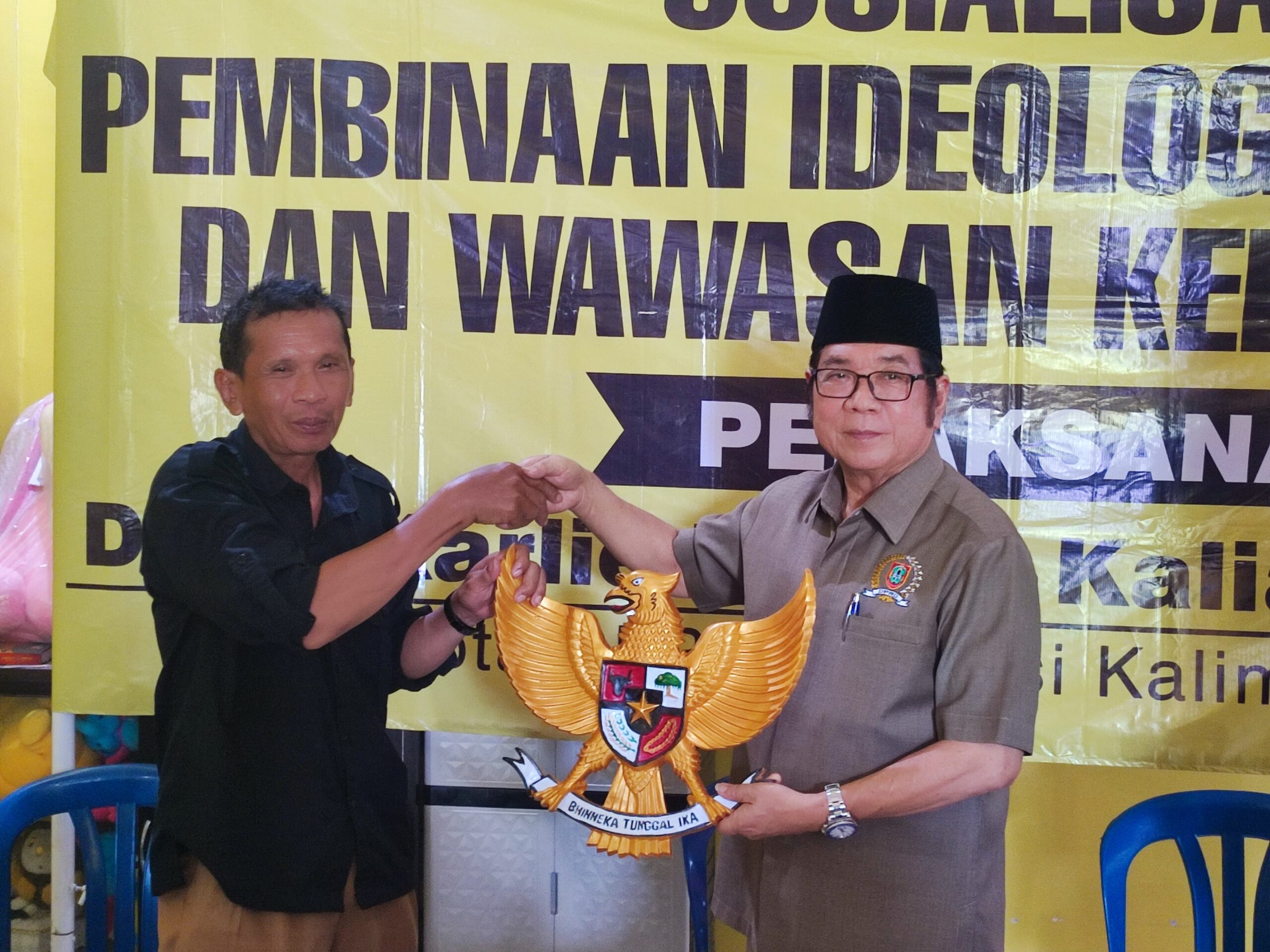 BURUNG GARUDA-Anggota Komisi II DPRD Provinsi Kalsel Dr H Karlie Hanafi Kalianda SH MH menyerahkan cenderamata berupa lambang negara Burung Garuda yang diterima Kepala Desa Semangat Dalam Kecamatan Alalak Kabupaten Batola, Senin (29/1/2024).(foto : ist)