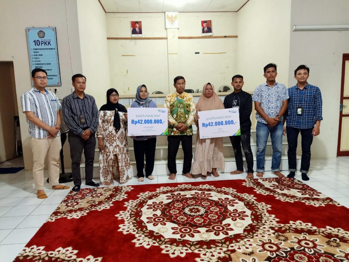 SERAHKAN SANTUNAN - Penyerahan santunan kepada almarhum Amiruddin dan Asri dilakukan secara simbolis oleh Kepala Cabang BPJS Ketenagakerjaan Pulau Laut Kotabaru Wisnu Wardhana. Ia didampingi  Drs Usman, selaku Kepada Desa Hilir Muara, Jumat (15/3/2024).(foto : ist)