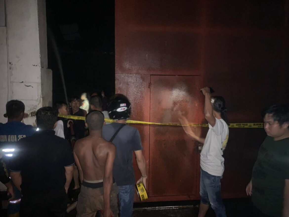 PADAMKAN KEBAKARAN - Pihak kepolisian saat memasang garis police akibar terbakarnya gudang miras di Jalan Belda Banjarmasin, Sabtu (2/3/2024) sore. (foto:ist)