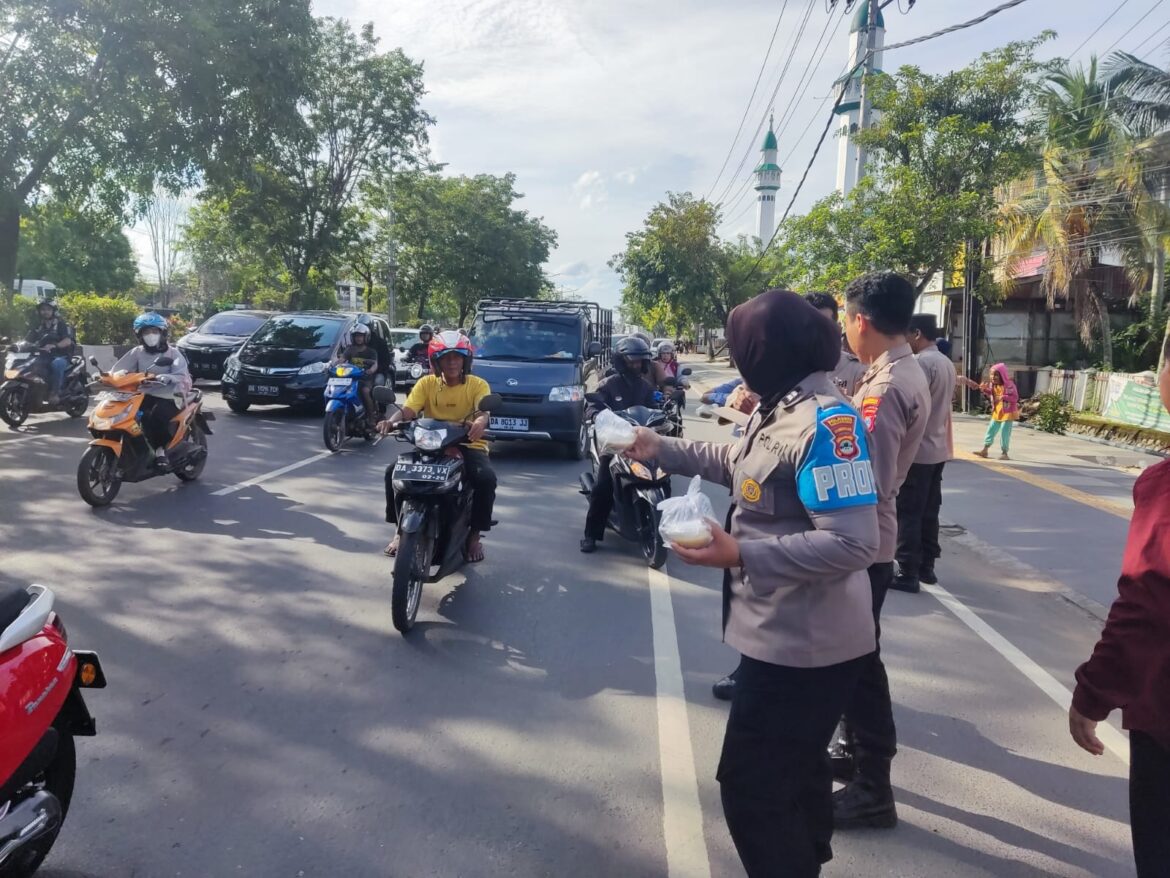 BAGI TAKJIL - Anggota Polsek Banjarmasin Timur saat bagi takjil di depab Mako Jalan A Yani Km 4, Kamis (14/3/2024) sore. (foto:ist)