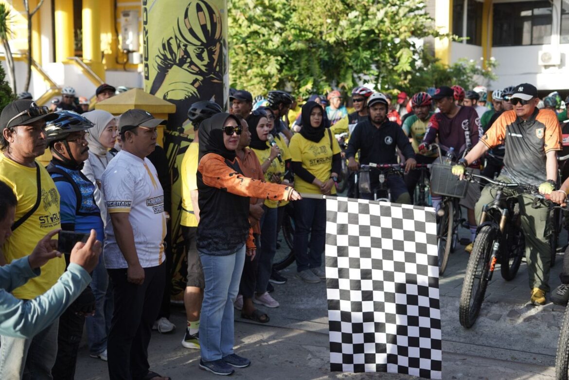 Ketua Dharma Wanita Persatuan (DWP) Dispora Kalsel, Rusnawati, mengibarkan bendera start melepas peserta Gowes Halal Bihalal Starling, Rabu (1/5/2024) pagi di halaman Kantor Dispora Kalsel, di Banjarmasin. (foto: Tolah/brt)