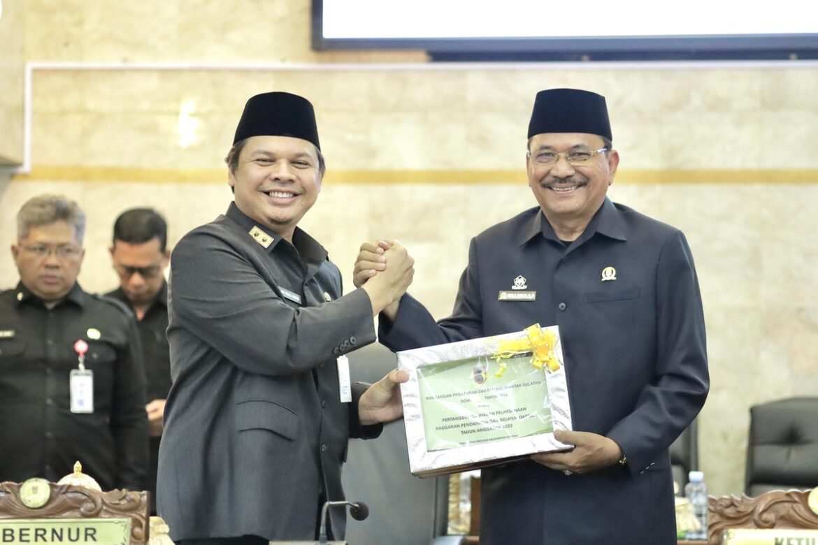 Sekdaprov Kalsel Roy Rizali Anwar wakili Gubernur Kalsel H Sahbirin Noor serahkan dokumen Raperda tentang Pertanggungjawaban Pelaksanaan APBD Tahun Anggaran 2023 kepada Ketua DPRD Provinsi Kalsel Dr (HC) H Supian HK, SH, MH dalam rapat paripurna.(foto : humasdprdkalsel)