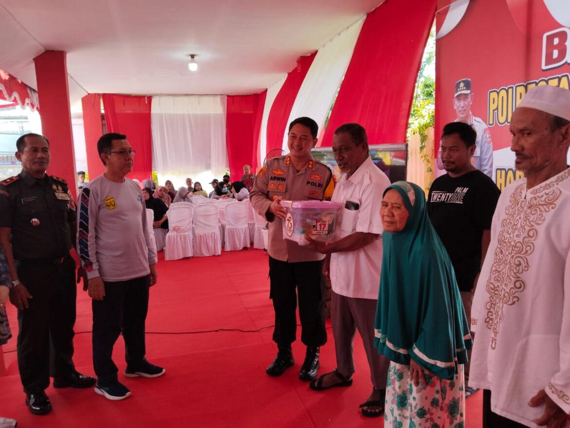 BAGIKAN SEMBAKO - Wakapolresta Banjarmasin AKBP Arwin Amrih Wientama saat menyerahkan sembako kepada warga tak mampu dalam Baksos di Polsek Utara, dalam rangka HUT ke 78 Bhayangkara, Selasa (25/6/2024) pagi. (foto:ist)