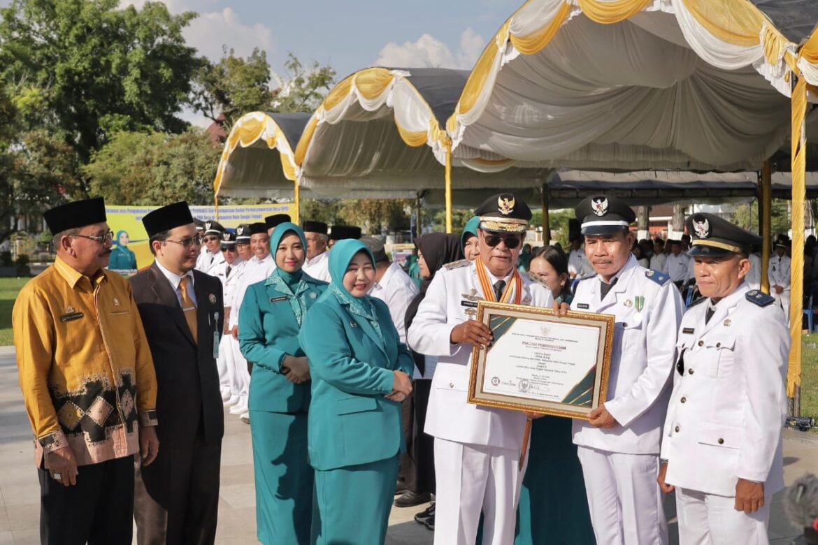 Gubernur Kalsel H Sahbirin Noor didampingi Ketua TP PKK Provinsi Kalsel Hj Raudatul Jannah, Ketua DPRD Proviinsi Kalsel H Supian HK dan Bupati HST H Aulia Oktafiandi menyerahkan piagam penghargaan kepada desa berprestasi di Kabupaten HST.(foto : humasdprdkalsel)
