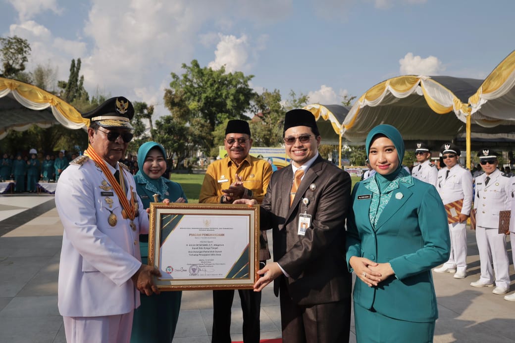 Gubernur Kalsel H Sahbirin Noor didampingi Ketua TP PKK Provinsi Kalsel Hj Raudatul Jannah, Ketua DPRD Proviinsi Kalsel H Supian HK menyerahkan piagam penghargaan kepada Bupati HST H Aulia Oktafiandi.(foto : humasdprdkalsel)