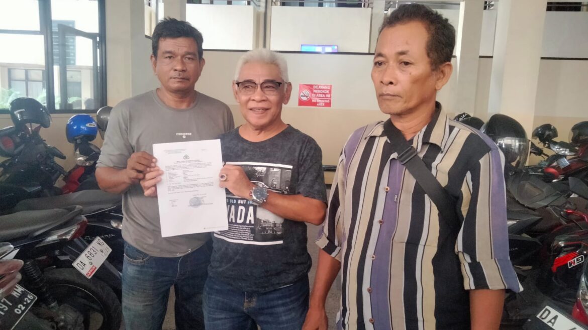 Martono (kiri) didampingi dua rekannya ketika memperlihatkam Laporan Polisi.