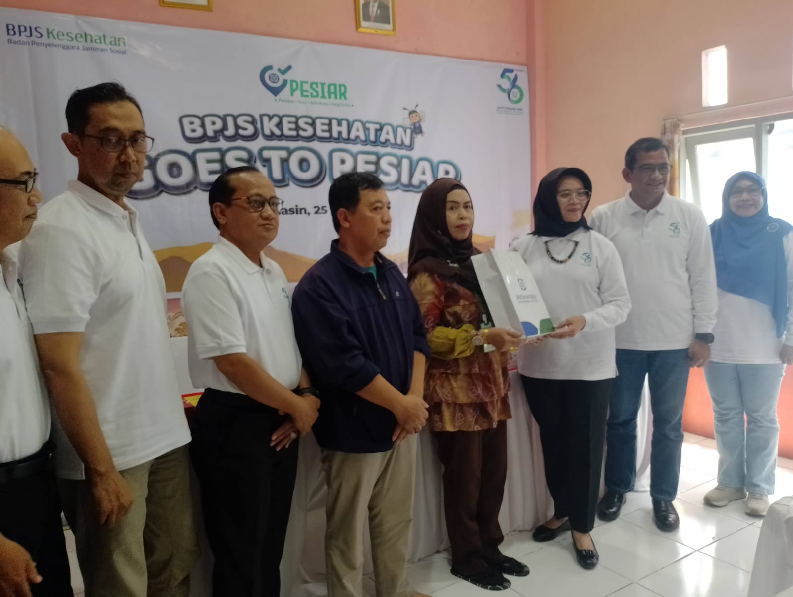 Dewan Pengawas Badan Penyelenggara Jaminan Sosial (BPJS) Kesehatan, Regina Maria Wiwieng Handayaningsih memberikan bingkisan kepada salah satu peserta  kegiatan Goes to PESIAR di  Kelurahan Pengambangan, Kota Banjarmasin Timur (foto:slm/ist)