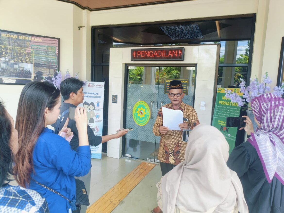 SERAHKAN SURAT - Penggugat Sojuangun mewakili istrinya, membacakan surat protes depan Pengadilan Negeri Banjarmasin, Selasa (24/9/2024).(foto: Mercy)