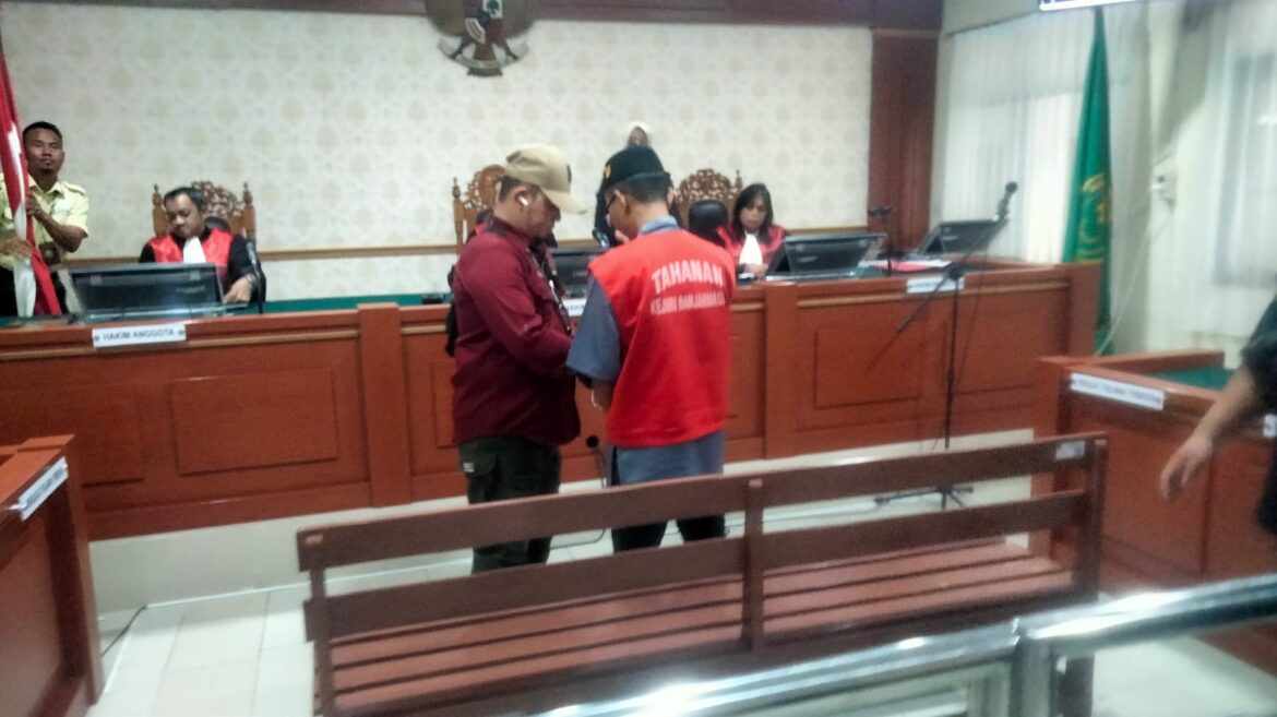 Terdakwa Maulani saat dikawal aparat menuju ruang sidang garuda PN Banjarmasin.