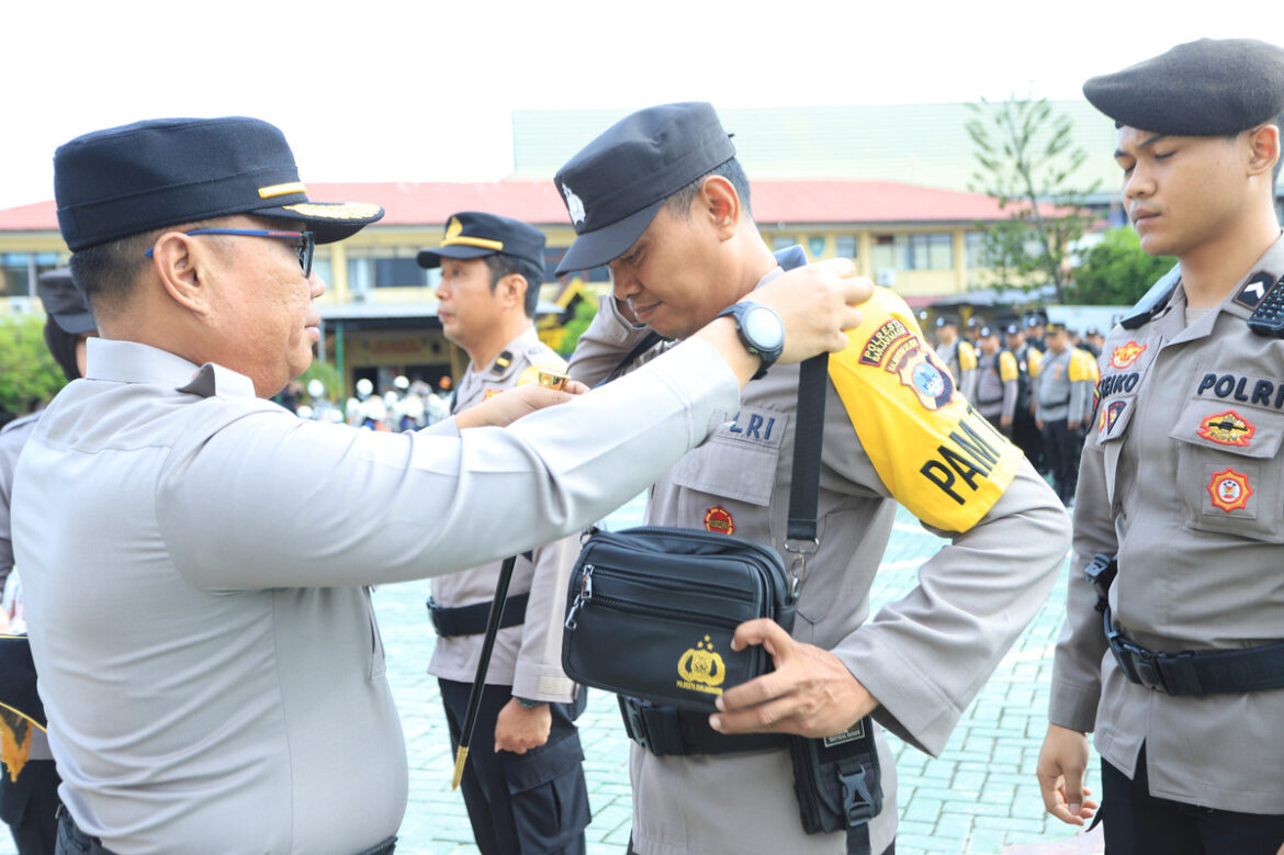 Kapolresta Banjarmasin Kombes Pol Cuncun Kurniadi saat memasang ban lengan tanda pengamanan petugas bergeser ke seluruh TPS dalam rangka Pencoblosan dan Perhitungan Pilkada Serentak 2024, Selasa 26/11/2024) pagi. (Ist)