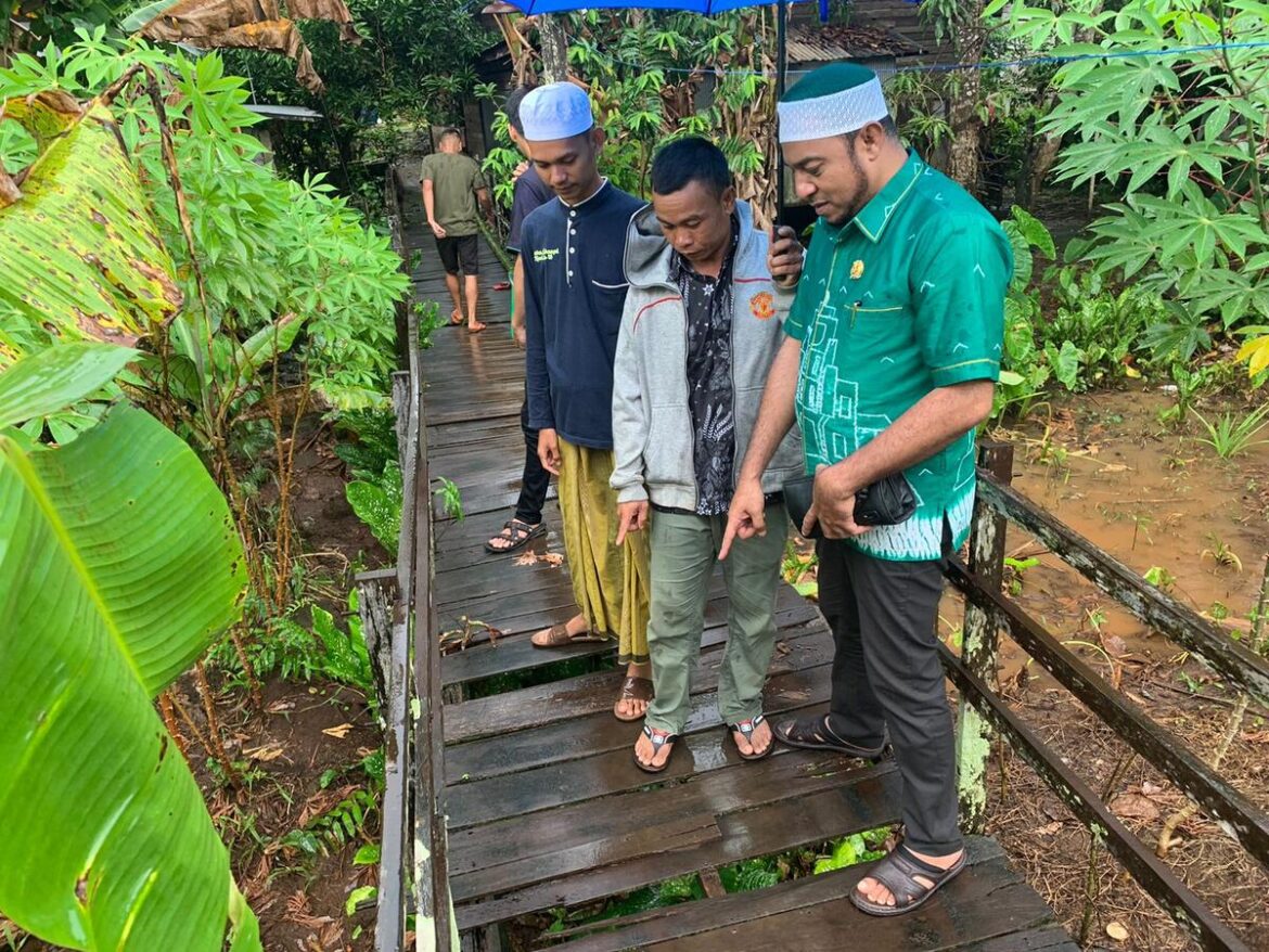 Habib Farhan Husein BSA didampingi Ketua RT di Desa Awang Bangkal Timur Kecamatan Karang Intan Kabupaten Banjar saat meninjau titian penghubung antar desa yang rusak.(foto : ist)