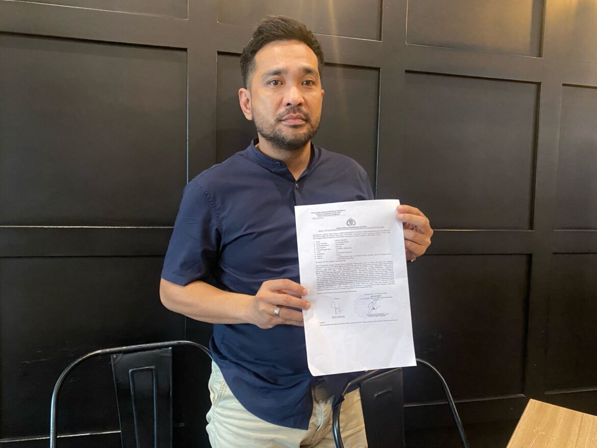 Reza, orang tua siswa menunjukan laporan kasus bulliying anaknya ke Polresta Banjarmasin.
