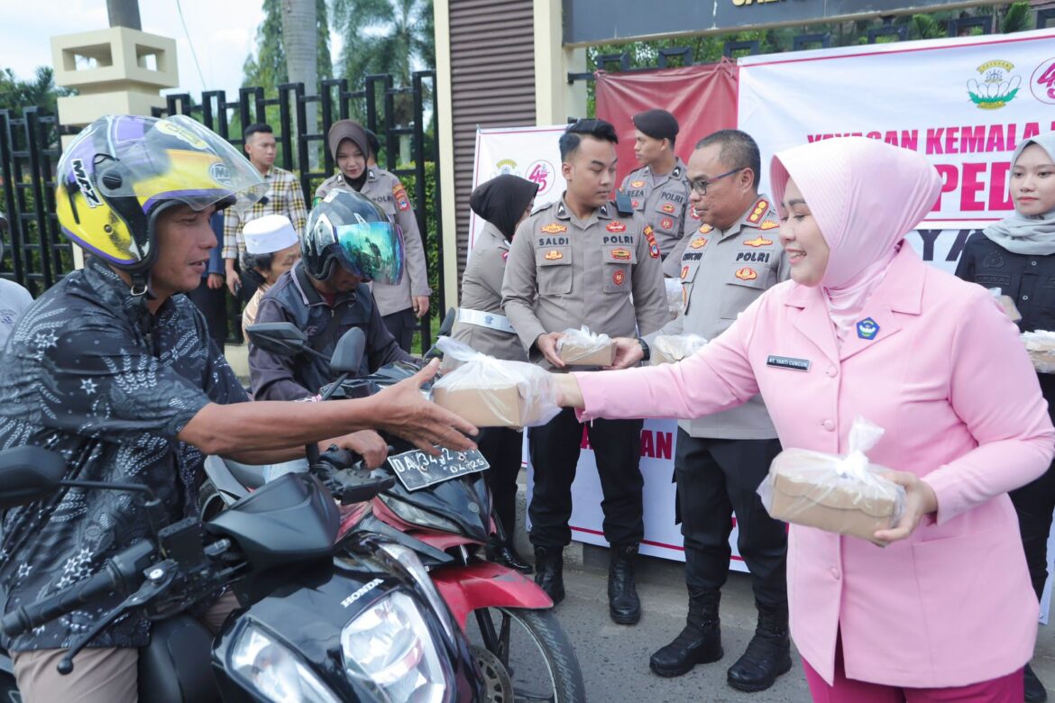 Ketua Bhayangkari Kota Banjarmasin, Yanti Cuncun Kurniadi, bersama Kapolresta Banjarmasin Kombes Pol Cuncun Kurniadi saat membagikan ratusan takjil kepada pengguna jalan, Selasa (18/3/2025). (Foto: Istimewa)