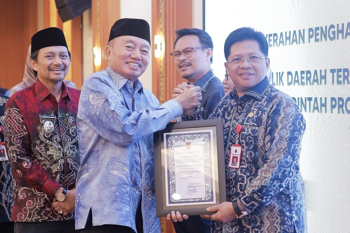 Sekretaris DPRD Provinsi Kalsel Muhammad Jaini saat menerima penghargaan yang diserahkan Gubernur Kalsel H Muhidin didampingi wakilnya H Hasnuryadi Sulaiman.(foto : humasdprdkalsel)