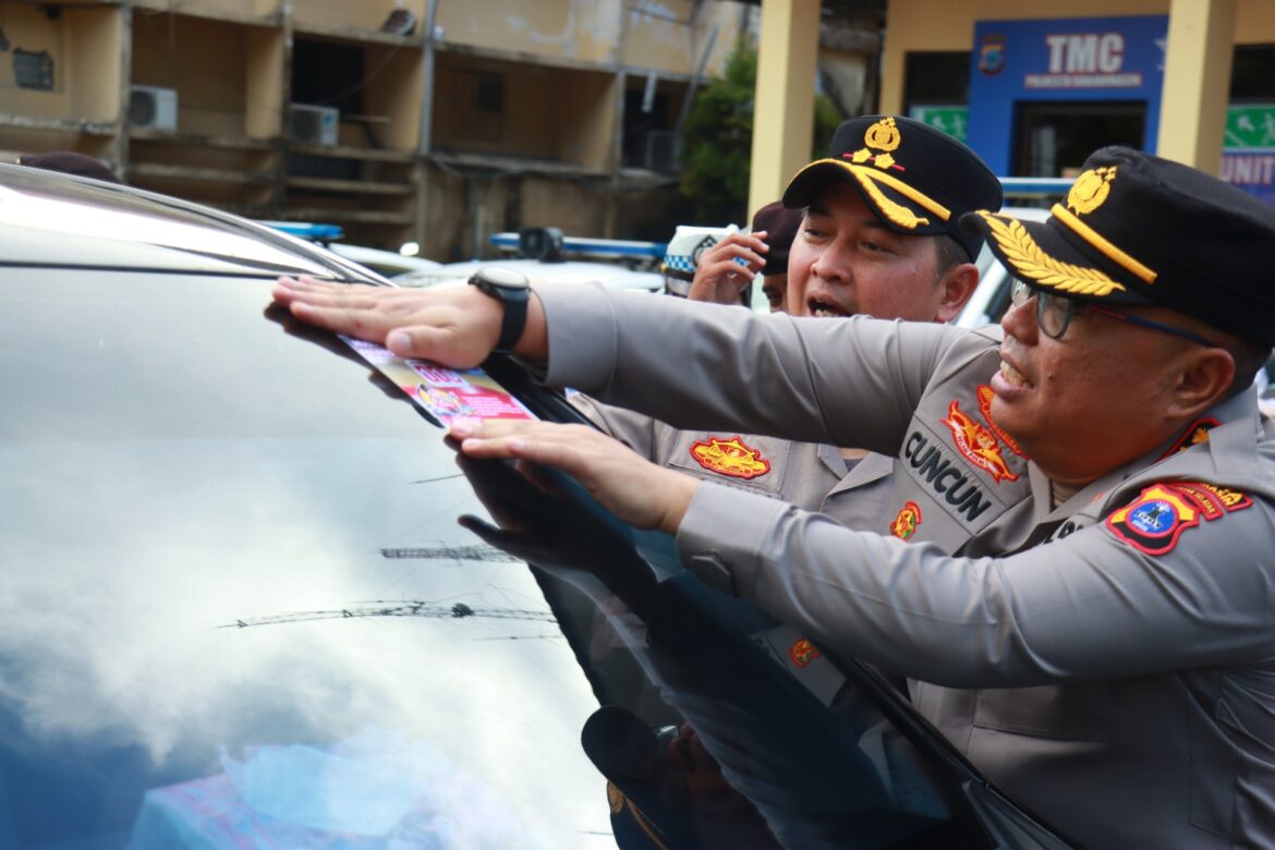 TEKS FOTO: Kapolresta Banjarmasin, Kombes Pol Cuncun Kurniadi didampingi Wakapolresta AKBP Arwin Ambil Wientama saat memasang stiker Hotline 110 dan Mudik Aman 2025, Minggu (16/3/2025) sore. (foto:istimewa)]