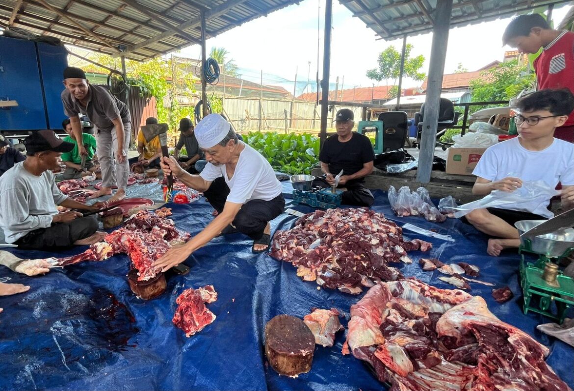 Pemimpin Umum Barito Post, H Guntur Prawira bersama karyawan dan keluarga besar, melakukan proses pemotongan hingga penyaluran daging hewan kurban, di Jalan Gunung Sari Raya, Kelurahan Teluk Dalam, Banjarmasin, Sabtu (7/6/2025). (foto : iman satria-brt).