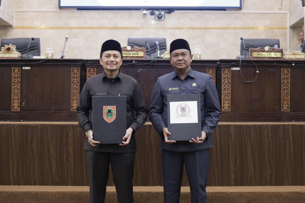 Wakil Gubernur Kalsel H Hasnuryadi Sulaiman dan Wakil Ketua DPRD Provinsi Kalsel h Kartoyo, SM perlihat dokumen penetapan Raperda tentang Pertanggungjawaban APBD Provinsi Kalsel Tahun Anggaran 2024 yang telah ditandatangani untuk ditetapkan menjadi Perda.(foto : humasdprdkalsel)