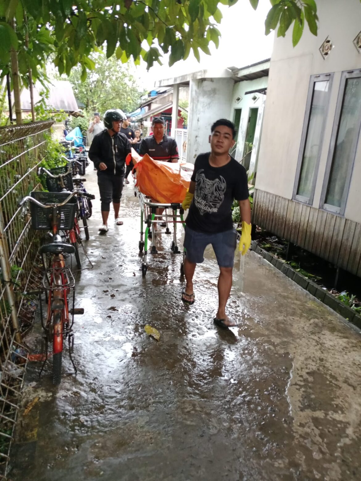 Beberapa relawan saat mengevakuasi korban tewas gantung diri di Jalan Gubernur Soebarjo Gang Tatah Selek RT 012 RW 01 Kelurahan Basirih Selatan, Kecamatan Banjarmasin Selatan, Kamis (17/7/2025) sore. (foto: istimewa)