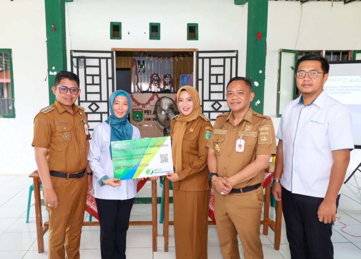 SERAHKAN KARTU - Kepala BPJS Ketenagakerjaan Batulicin Vina Dwina Yuskin saat menyerahkan kartu BPJS program Ekosistem Desa kepada perangkat Desa Muara Pagatan Tengah, Sabtu (29/9/2025).(foto : istimewa)