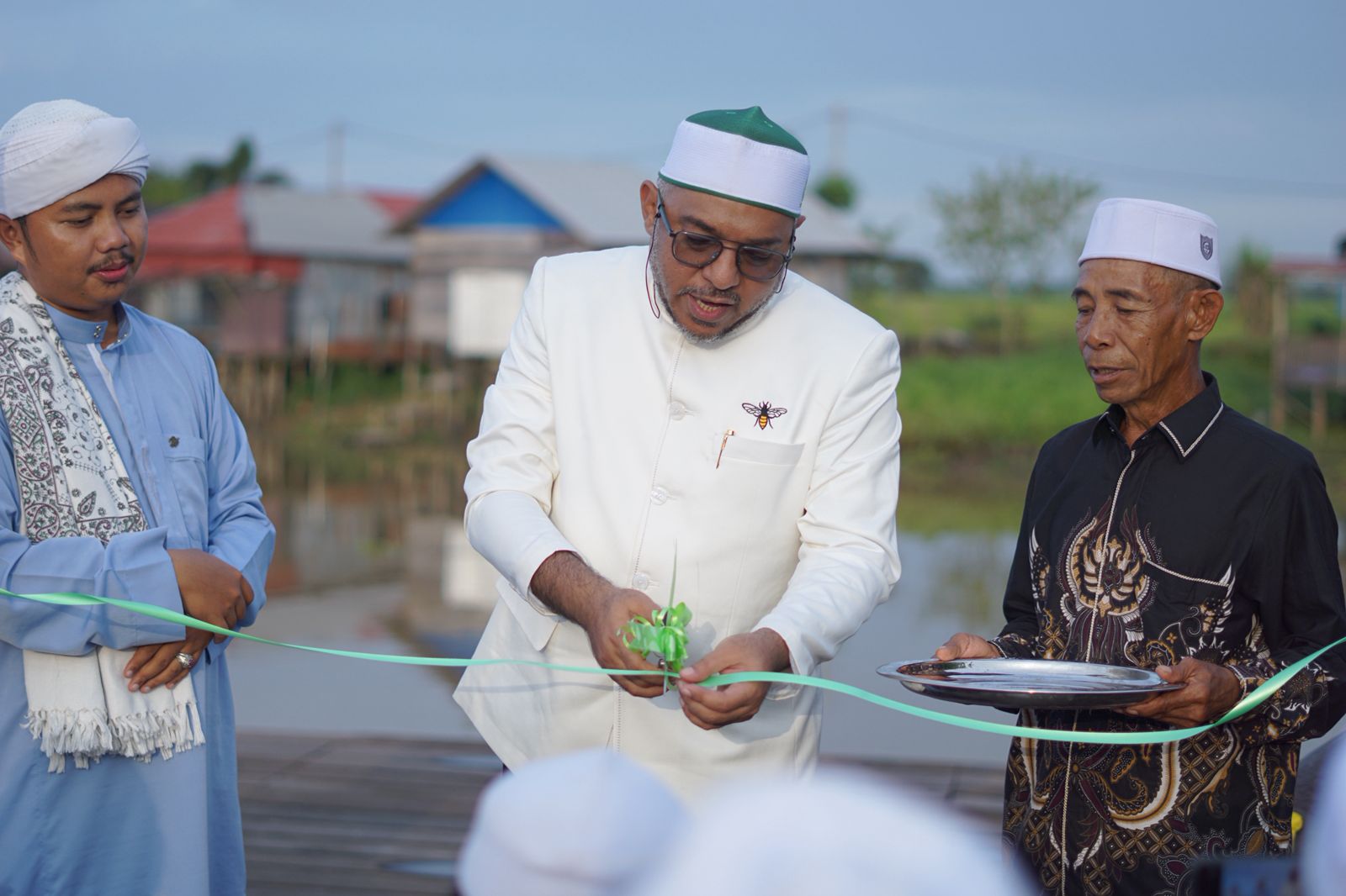 Anggota Komisi III DPRD Provinsi Kalsel Habib Farhan BSA saat gunting pita tanda peresmian dermaga kecil di Desa Tajau Landung Kecamatan Sungai Tabuk Kabupaten Banjar.(foto : ist)