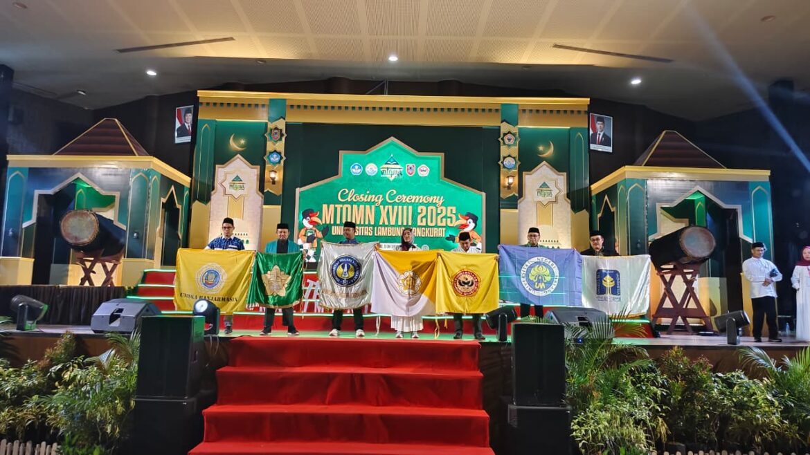 Wakil Rektor III Uniska MAB Memegang Logo Bendera Uniska MAB di Closing Ceremony MTQM Nasional XVIII 2025 (sebelah bagian kiri)