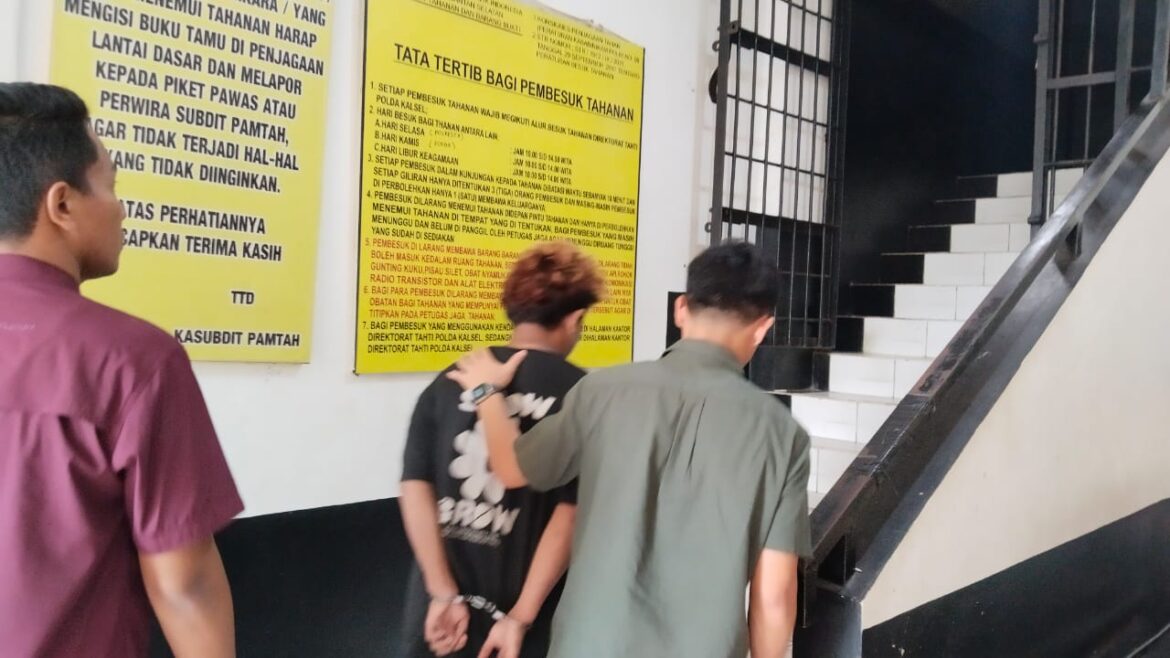 Pelaku (tengah) terduga pemerasan video asusila anak SD saat dibekuk Sat Reskrim Polresta Banjarmasin, Kamis (20/11/2025).