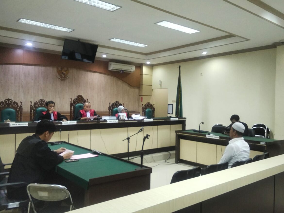 Terdakwa Evan saat mendengarkan dakwaan JPU pada sidang perdana di Pengadilan Tipikor Banjarmasin.