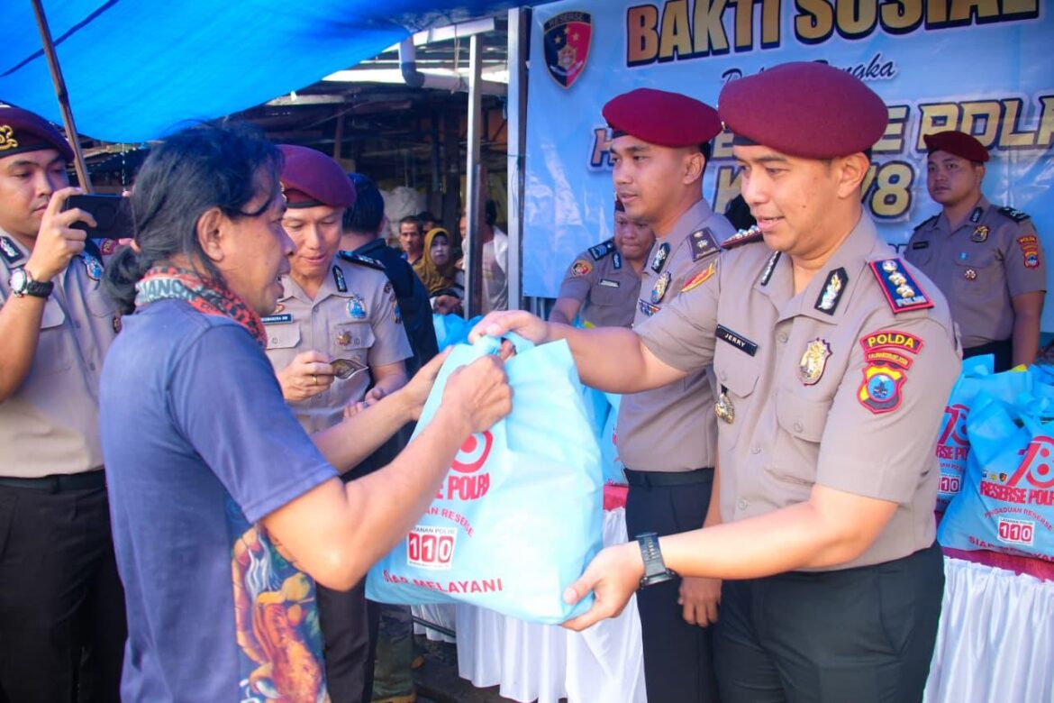 Sejumlah anggota Reserse Polda Kalsel menyerahkan paket sembako kepada warga (Foto Iman Satria)