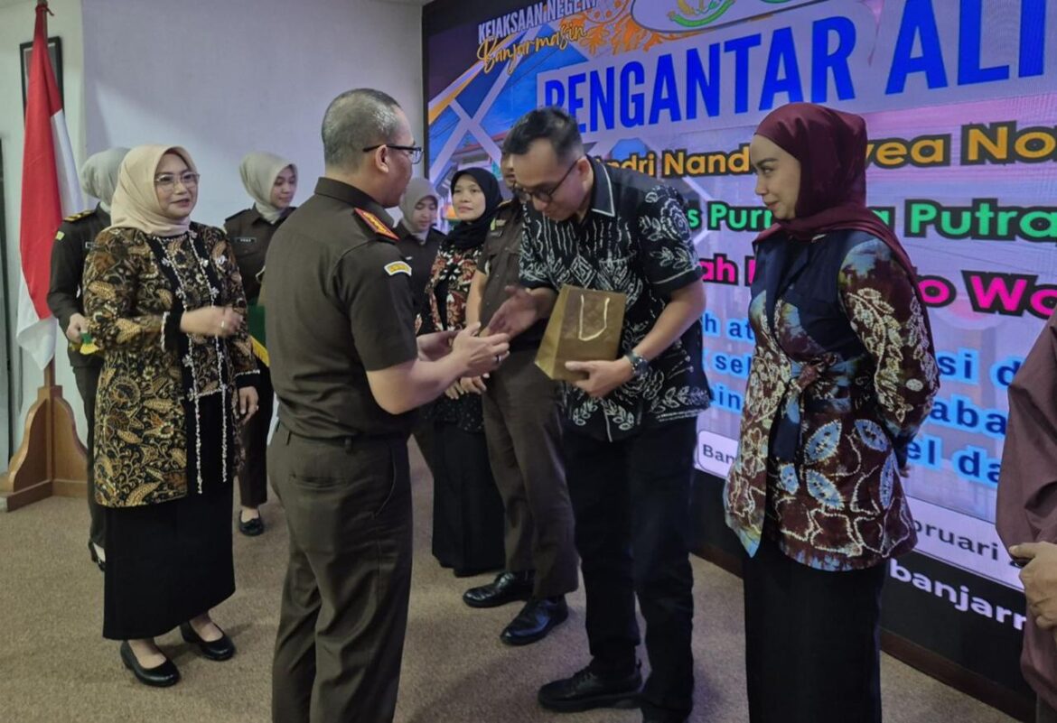 Kajari Banjarmasin Eko Riendra Wiranto memberikan cindera mata kepada Dimas Purnama Putra yang mendapatkan promosi jabatan menjadi Kasi Datun Kejari Batam, saat pisah sambut di Kejari Banjarmasin, Kamis (12/2/2026). (foto : iman satria/brt)