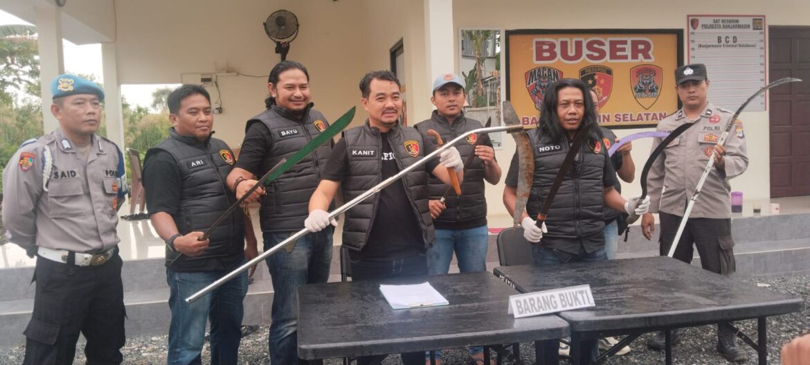 GELAR BARBUK - Kanit Reskrim Polsek Banjarmasin Selatan, AKP Joko saat menggelar barang bukti sajam belasan anak yang diamankan hingga kedapatan simpan sajam, Minggu (15/2/2026). (foto:sum/brt)