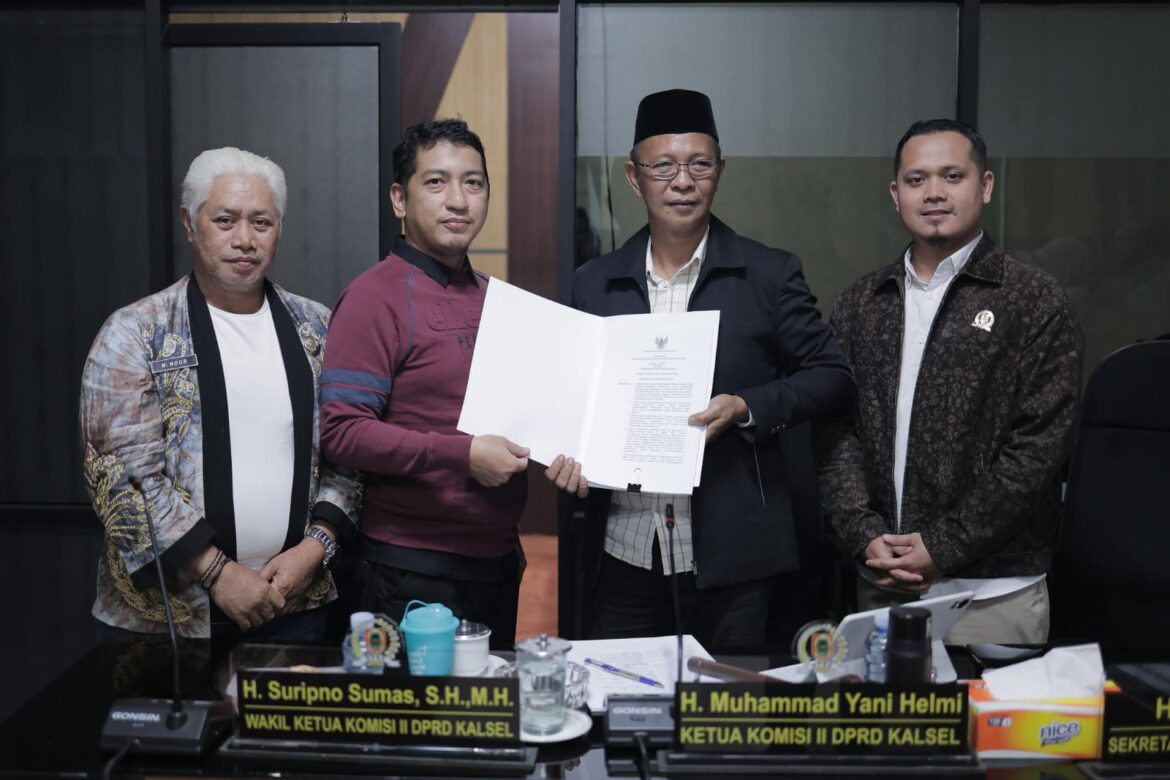 FINALISASI RAPERDA-Ketua Pansus II DPRD Provinsi Kalsel Muhammad Yani Helmi (pakai peci) perlihatkan dokumen finalisasi Raperda tentang Penyelenggaraan Perdagangan yang telah ditandatangani.(foto : humasdprdkalsel)
